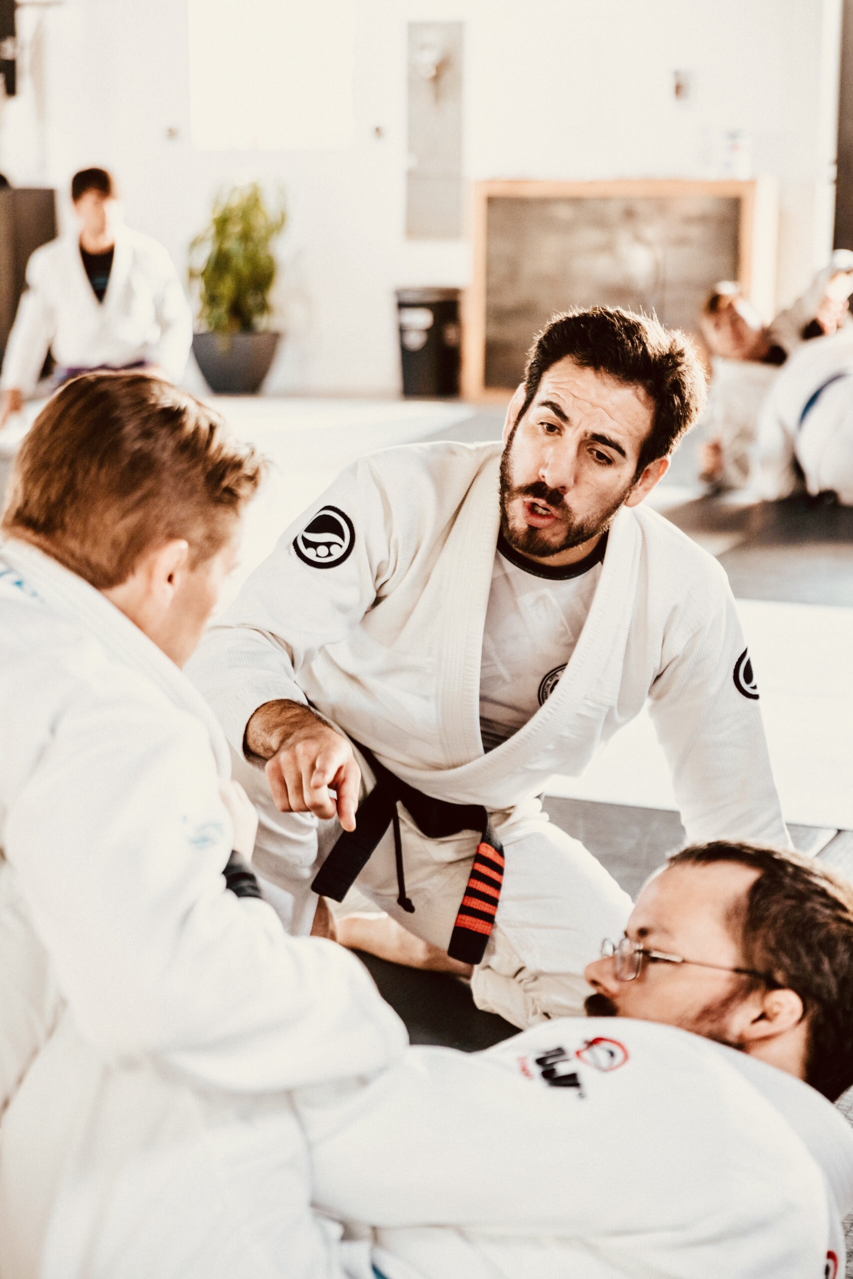 Sportschutzschiene Neunkirchen - Dr. Alexander Puchner, MSc Symbolfoto Sportschutzschiene Neunkirchen: Zwei Männer beim Judo-Training, im Hintergrund gibt der Trainer Anweisungen.